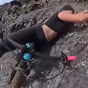 Daredevil Cycling Beauty's Cliffhanger Adventure with Her Loyal Pup