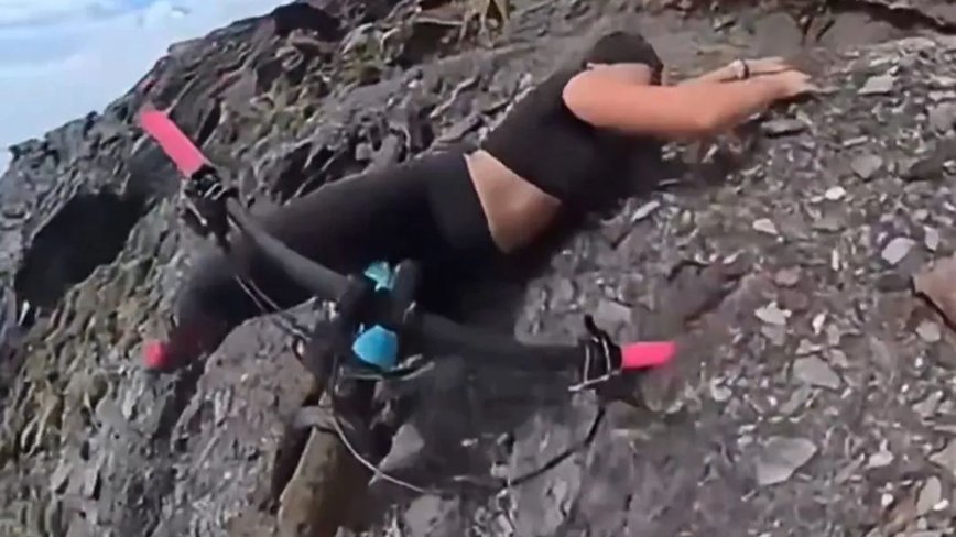 Daredevil Cycling Beauty's Cliffhanger Adventure with Her Loyal Pup